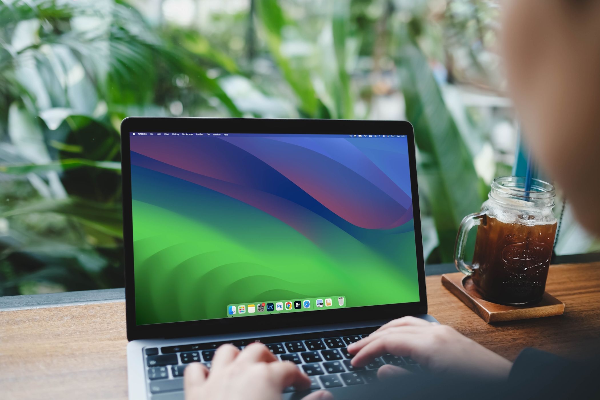 زنی در حال تایپ کردن با مک بوک ایر دارای macOS Sonoma