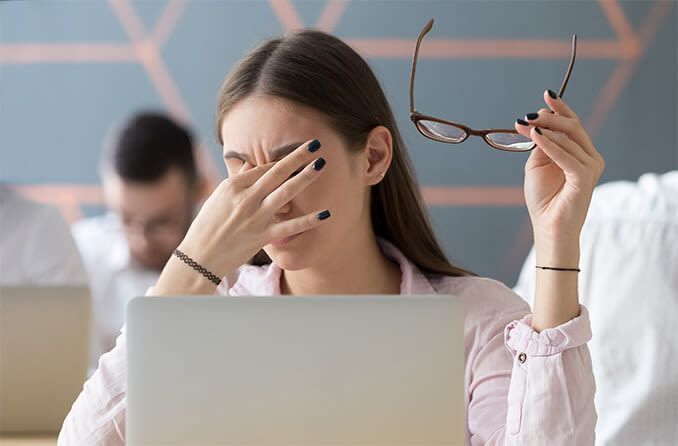 یک زن به دلیل فشار دیجیتال چشم ، چشمان خود را مالش می دهد
