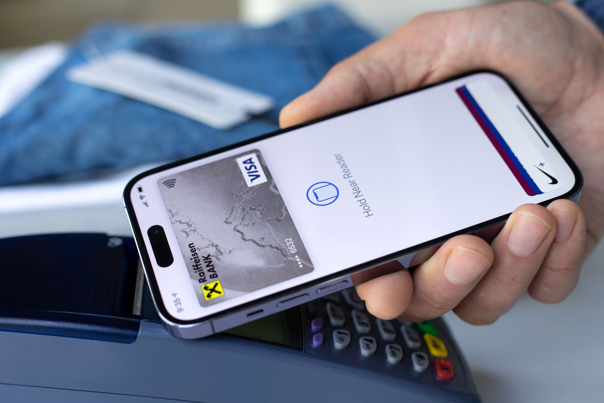 مردی که از Apple Pay در آیفون برای معامله بازرگان استفاده می کند