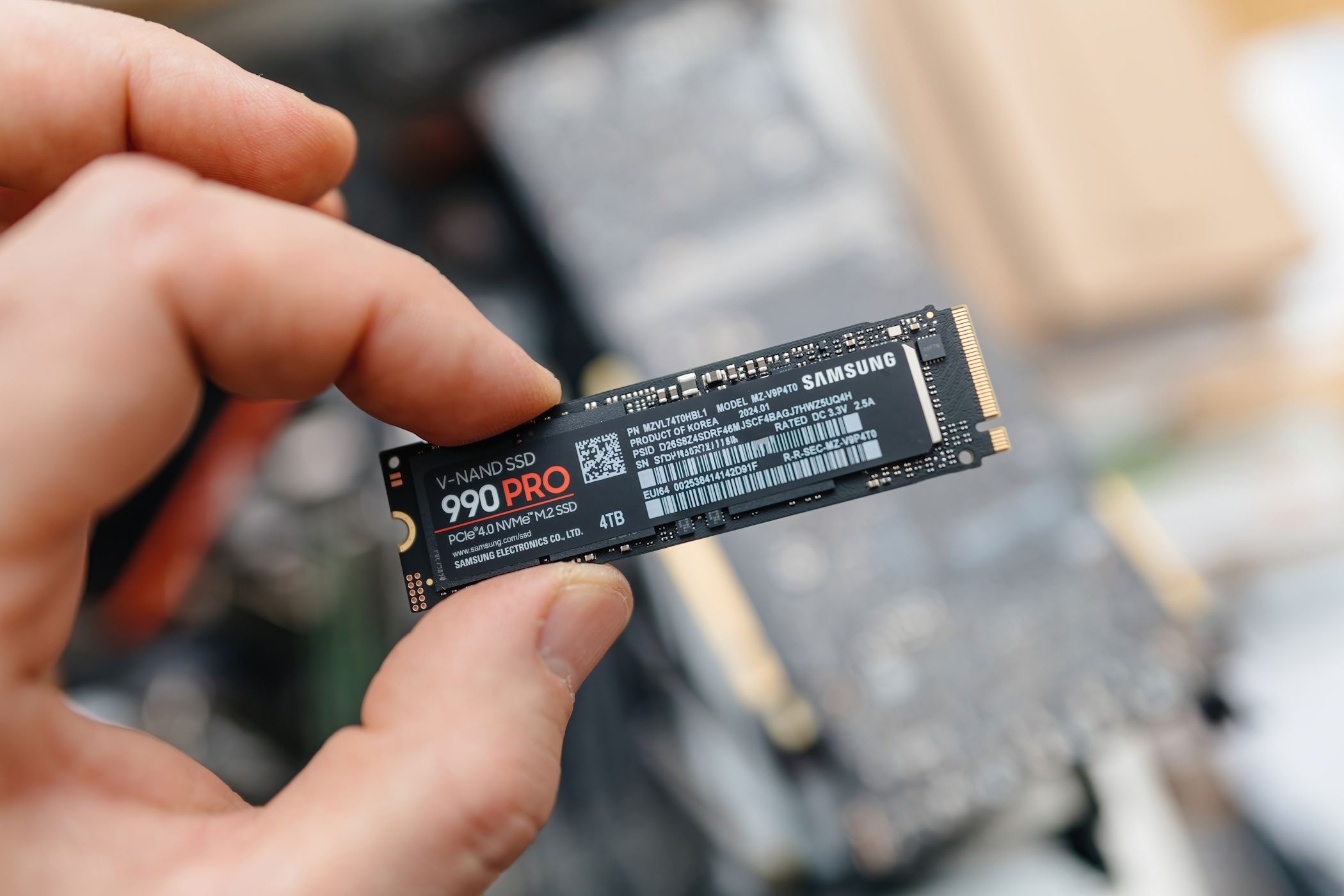مردی که سامسونگ 990 Pro SSD را در دست دارد