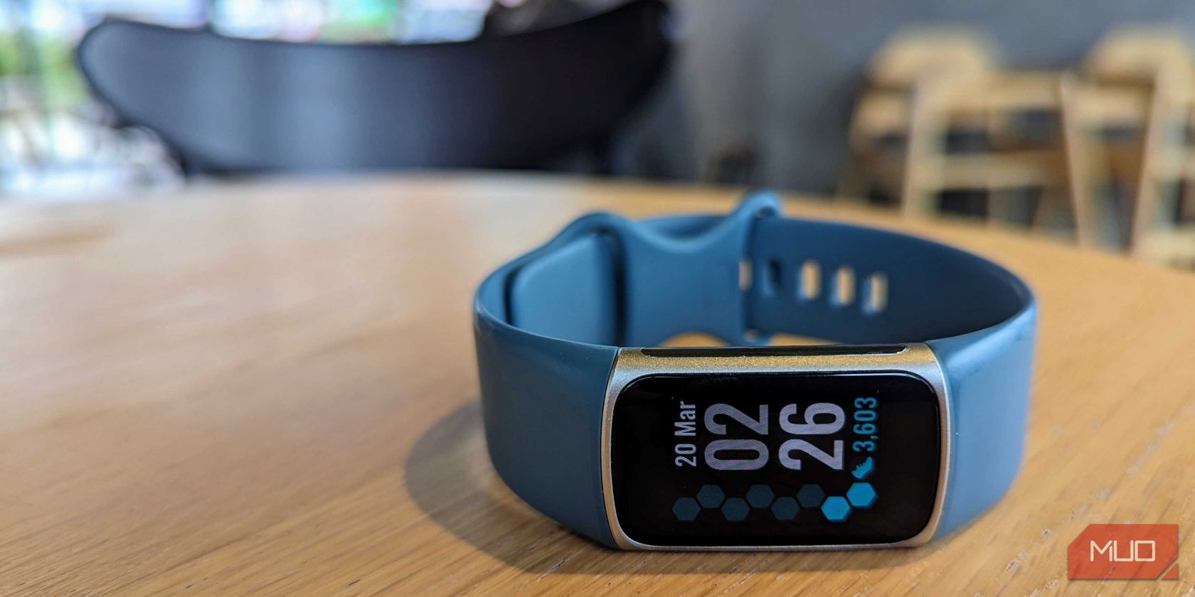شارژ Fitbit 5 روی یک میز در یک کافه