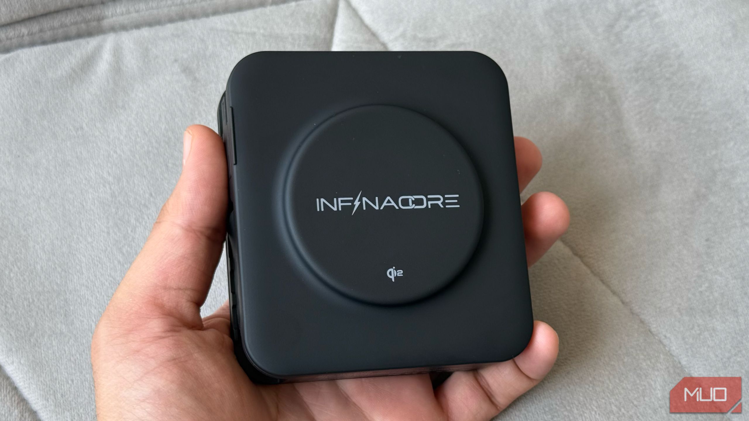 Hand Holding Infinacore P3 Pro نشان دادن پد شارژ بی سیم Qi2