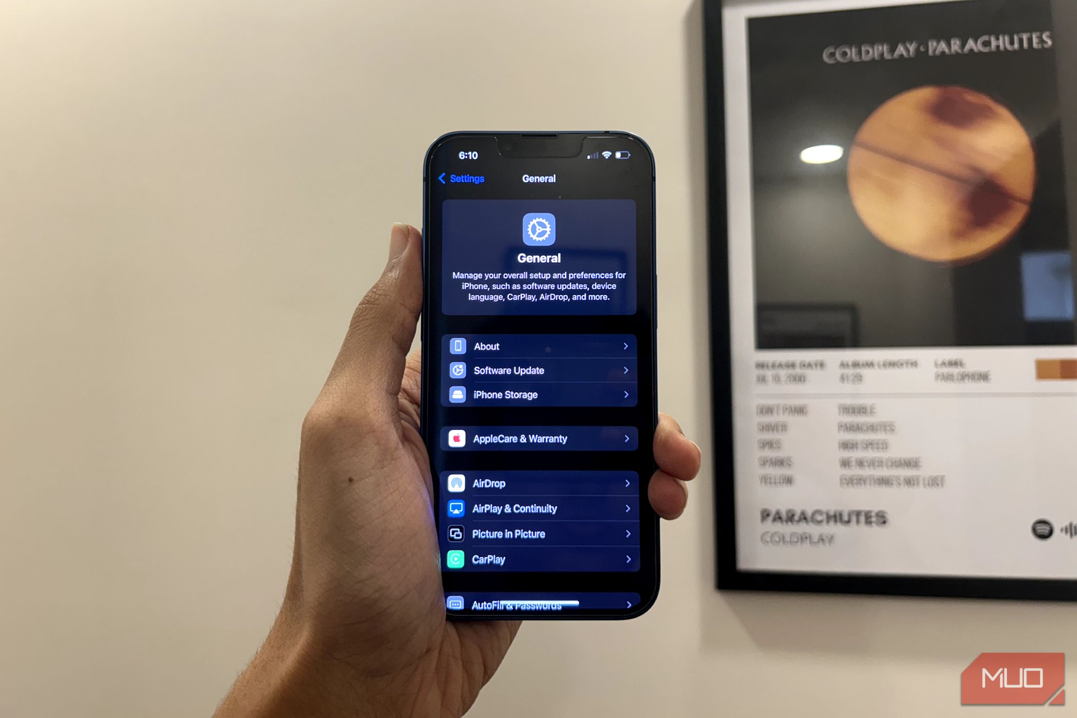 مردی که دارای آیفون است که برنامه تنظیمات طراحی مجدد را در iOS 18 نشان می دهد