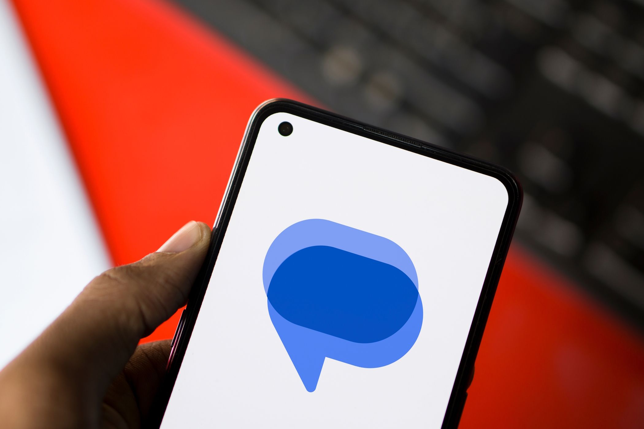 آرم پیام های Google در یک تلفن اندرویدی با صفحه کلید در پس زمینه ظاهر می شود