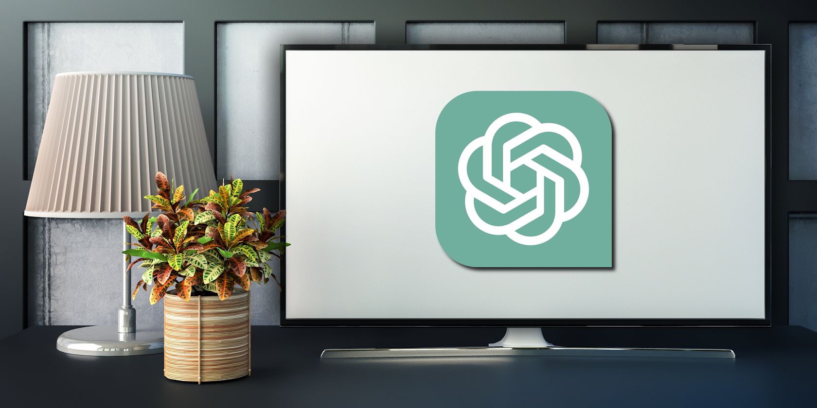 آرم Chatgpt در مانیتور رایانه روی میز با گیاه