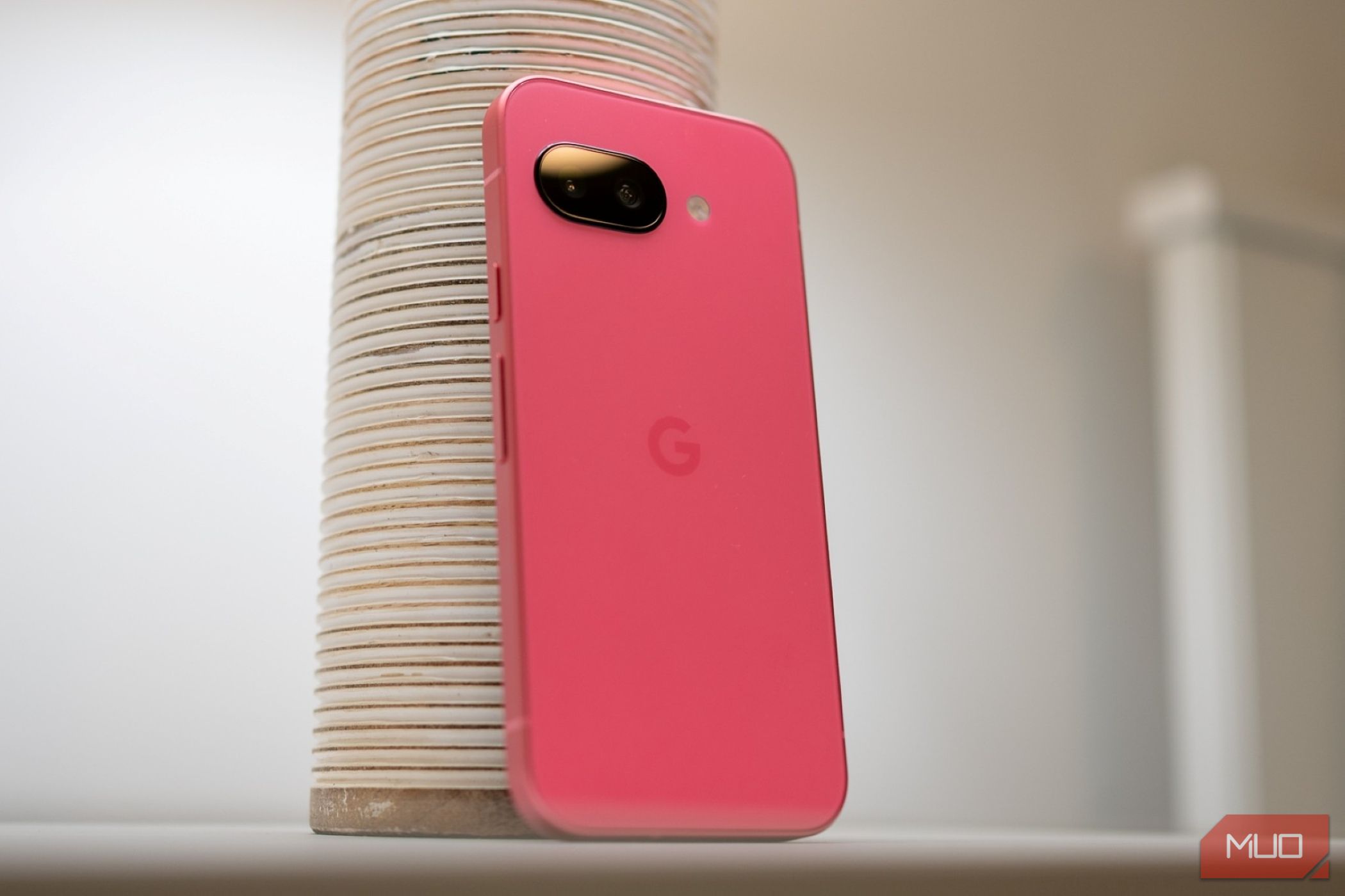 Google Pixel 9a روی یک میز نشسته است که پشت تلفن را نشان می دهد