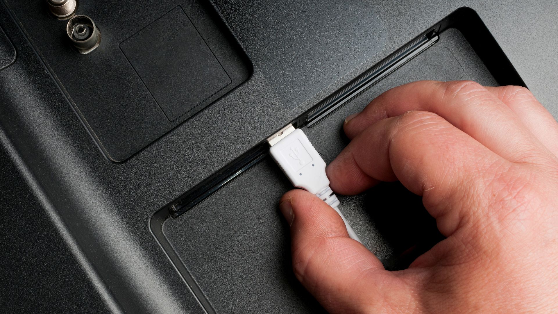 مرد وصل می شود کابل USB را به درگاه های عقب تلویزیون نوع