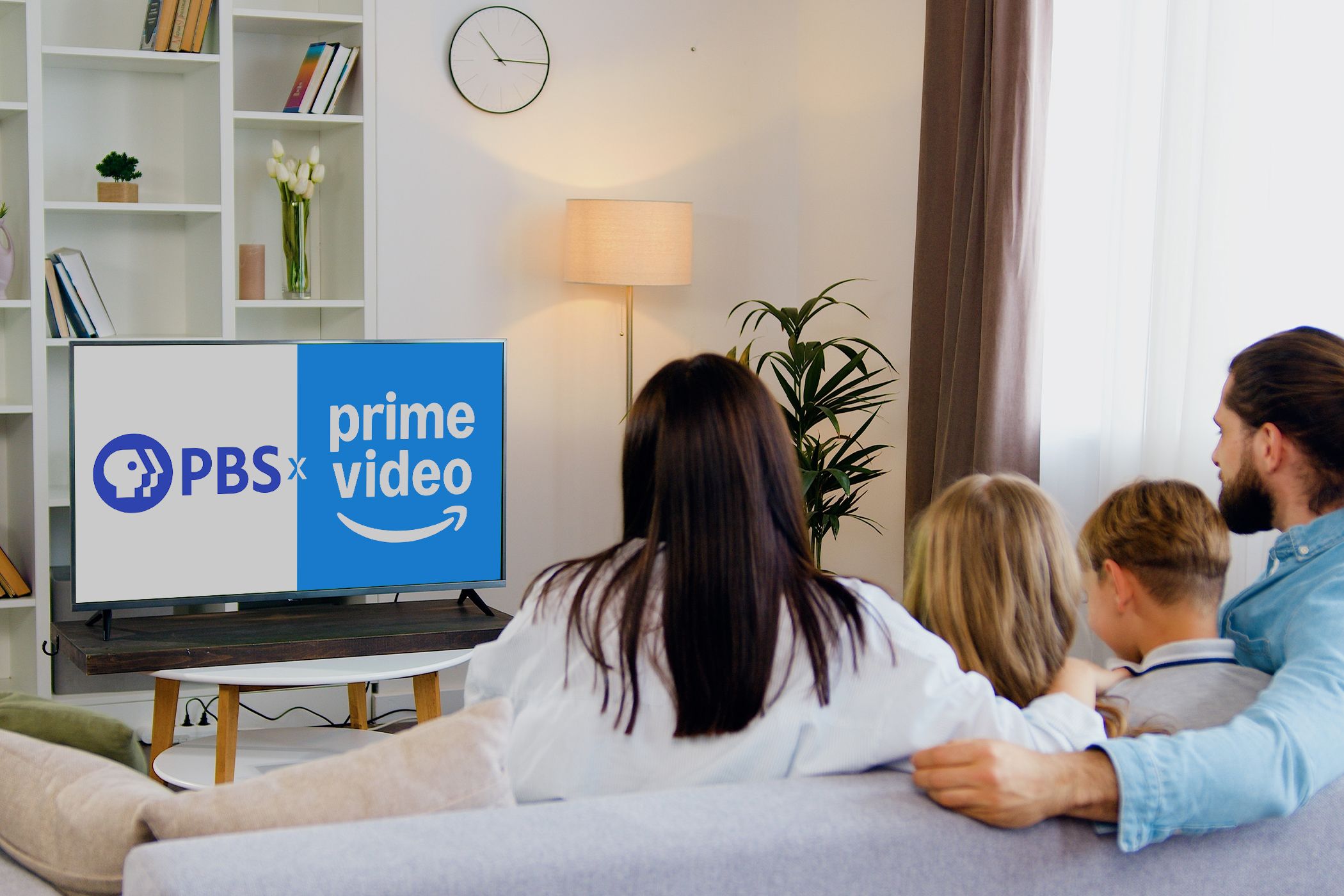 آرم های PBS و Prime Video در تلویزیون یک خانواده در اتاق نشیمن تماشا می کنند