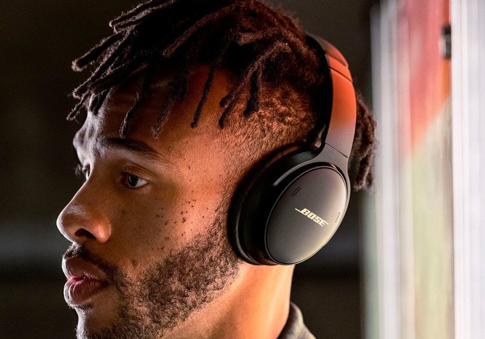 مردی که از موسیقی در هدفون Bose QuietComfort 45 لذت می برد.