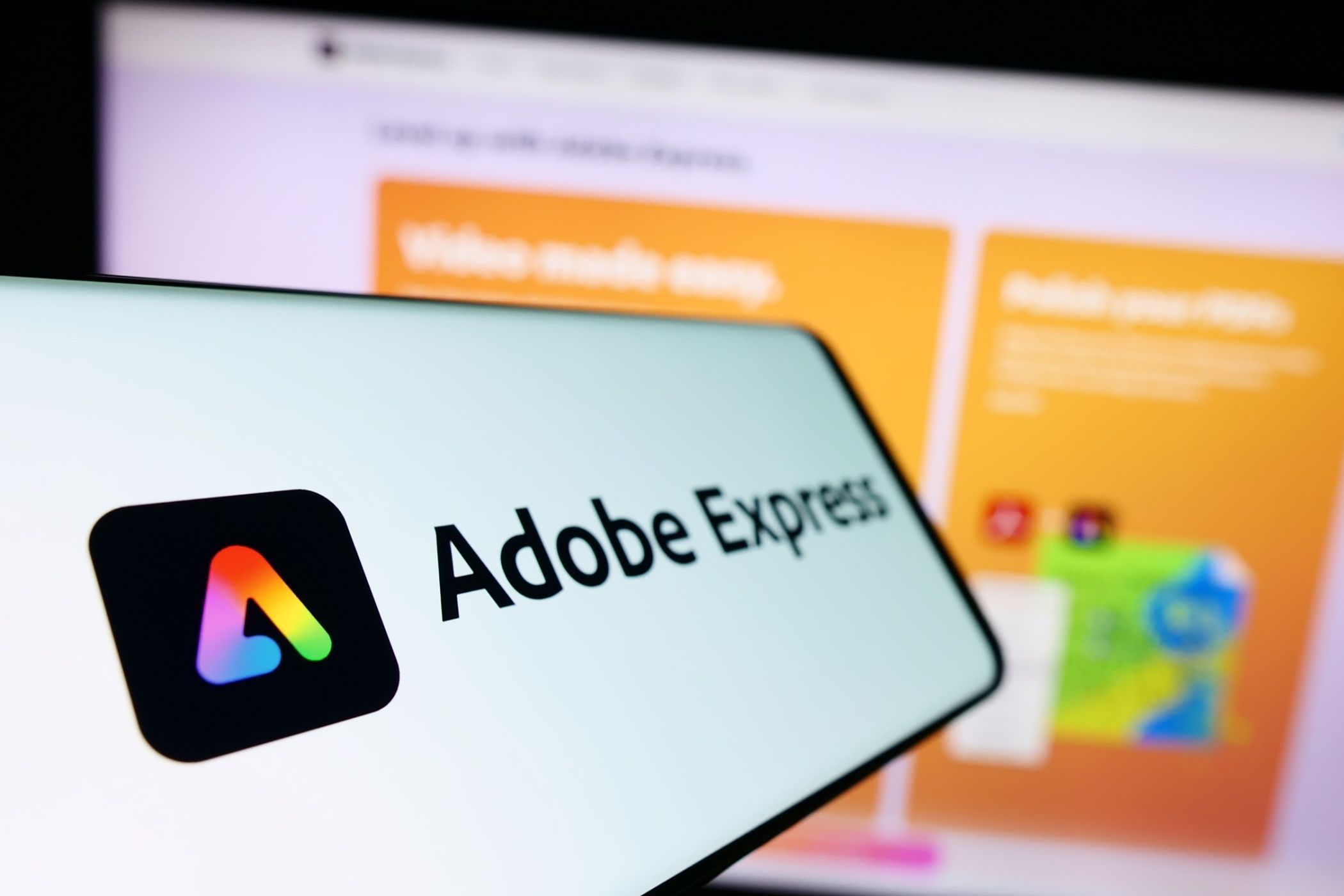 آرم Adobe Express در تلفن هوشمند ، با طراحی رایانه در پس زمینه