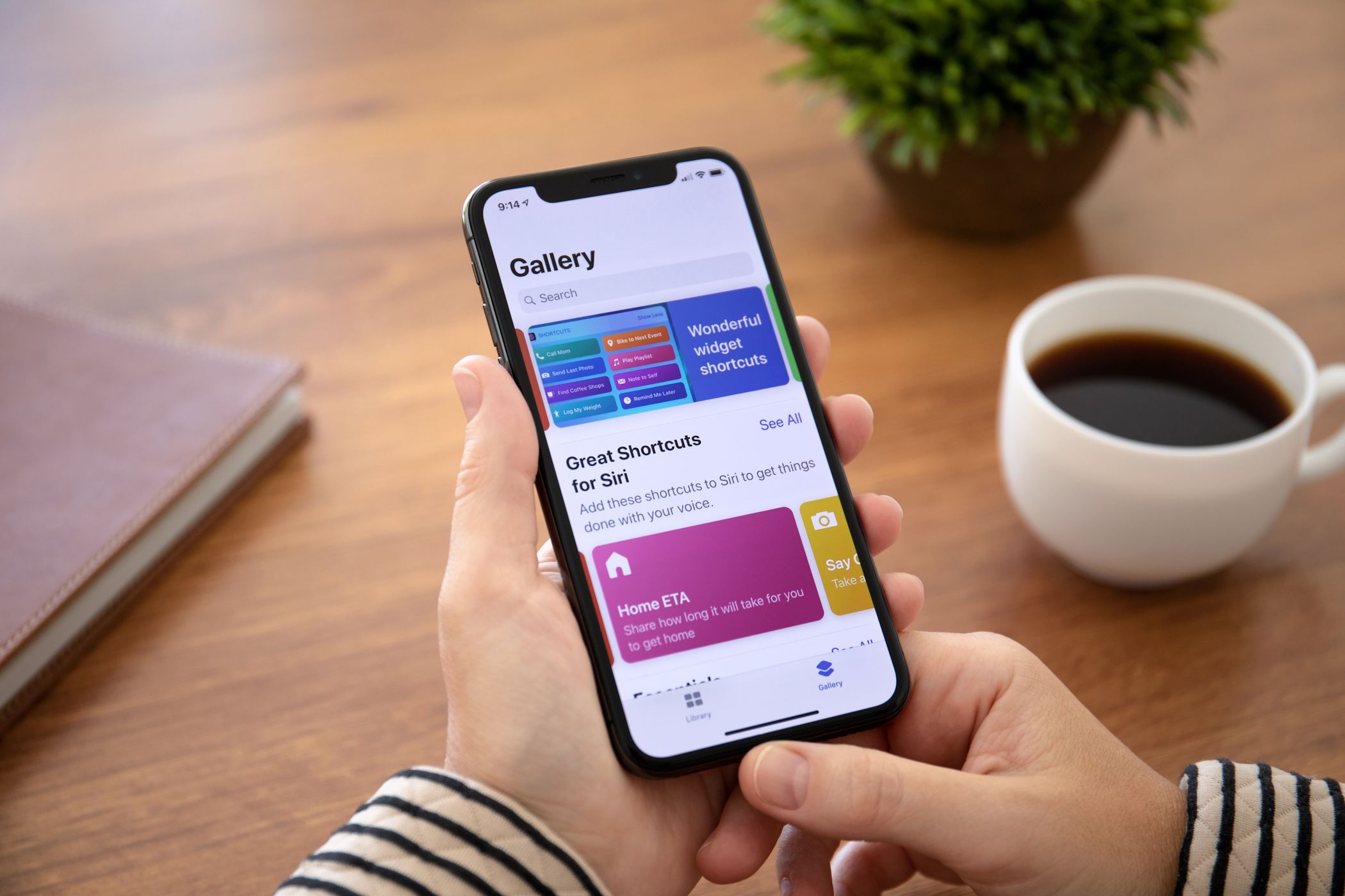 زنی که آیفون را در دست دارد بخش گالری برنامه میانبر iOS را نشان می دهد