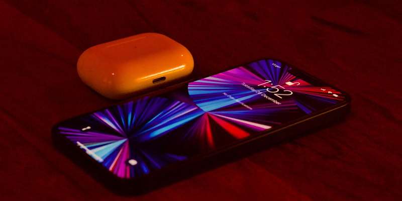 یک مورد آیفون و AirPod که روی یک میز نشسته است