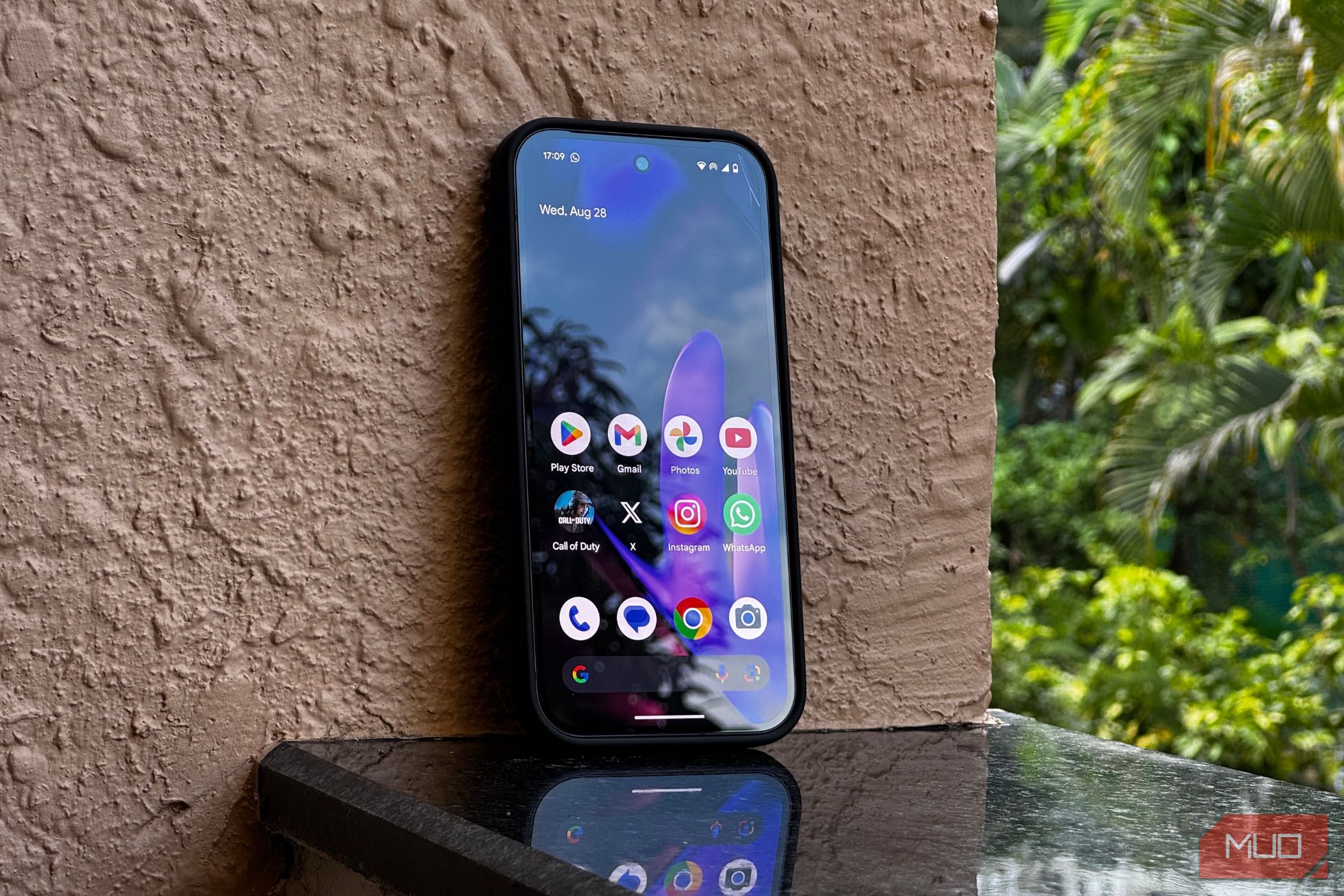 Google Pixel 9 در مقابل دیواری که نمایشگر آن را نشان می دهد استراحت می کند