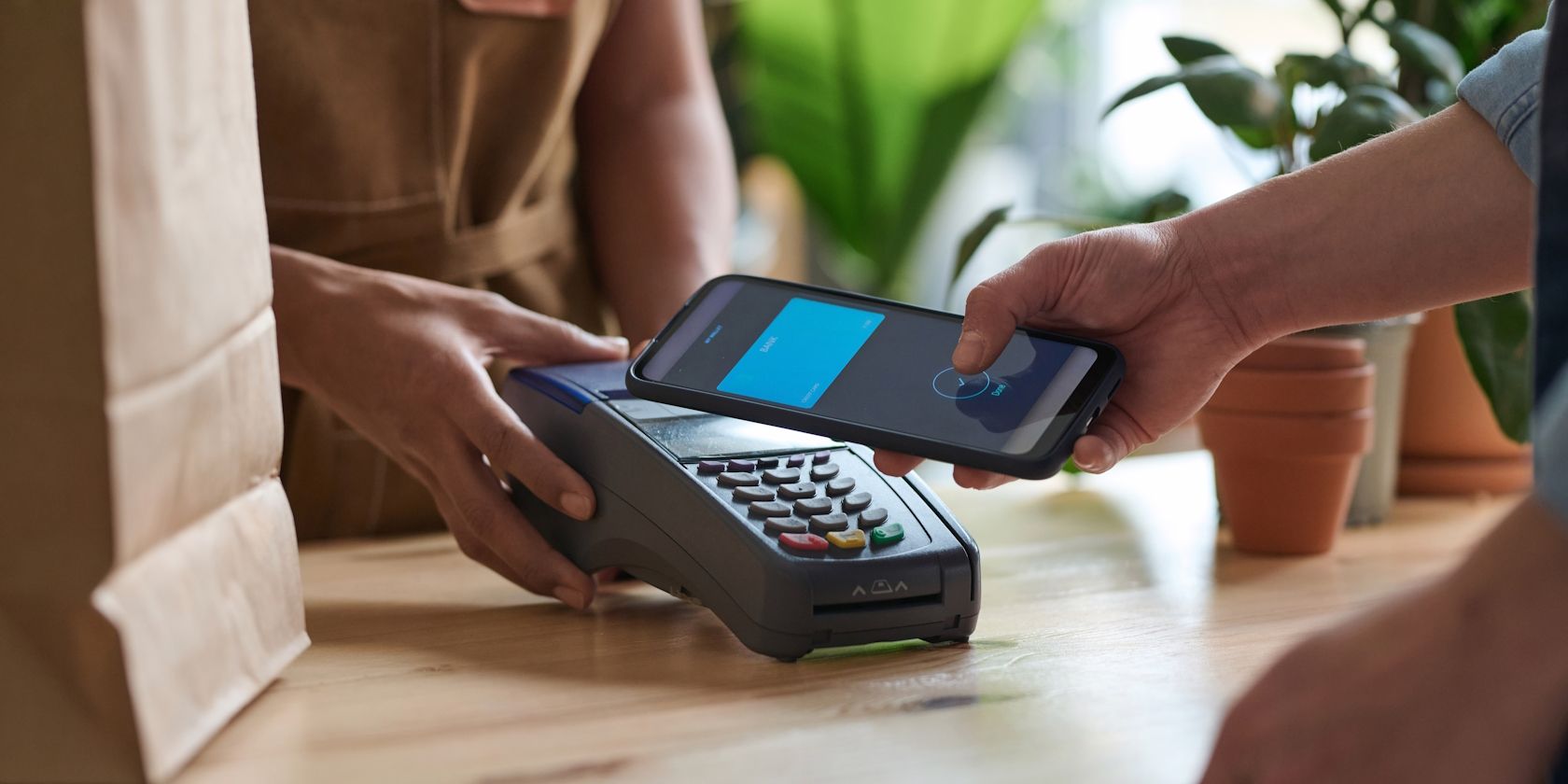 مردی که با استفاده از تلفن هوشمند خود در یک فروشگاه مواد غذایی ، پرداخت NFC را انجام می دهد