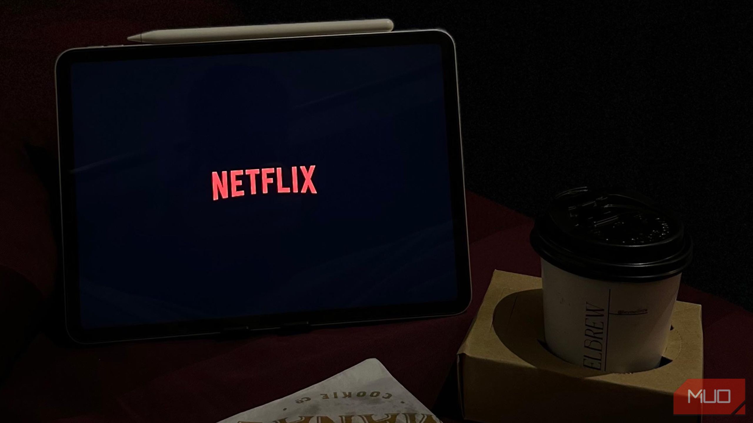 صفحه نمایش Netflix در یک iPad در کنار یک فنجان قهوه