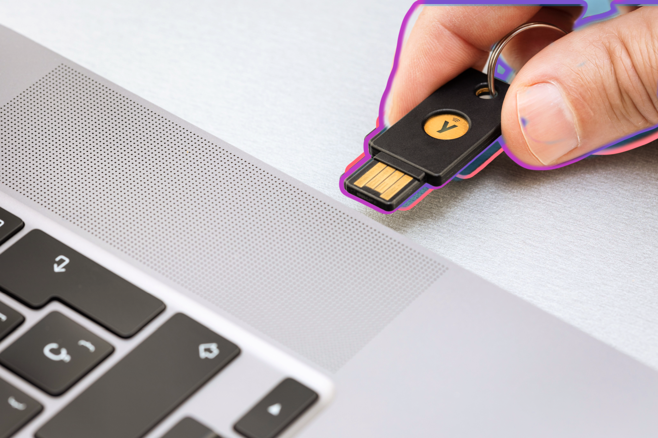 شخصی که کلید امنیت فیزیکی Yubico را در بندر USB لپ تاپ قرار می دهد