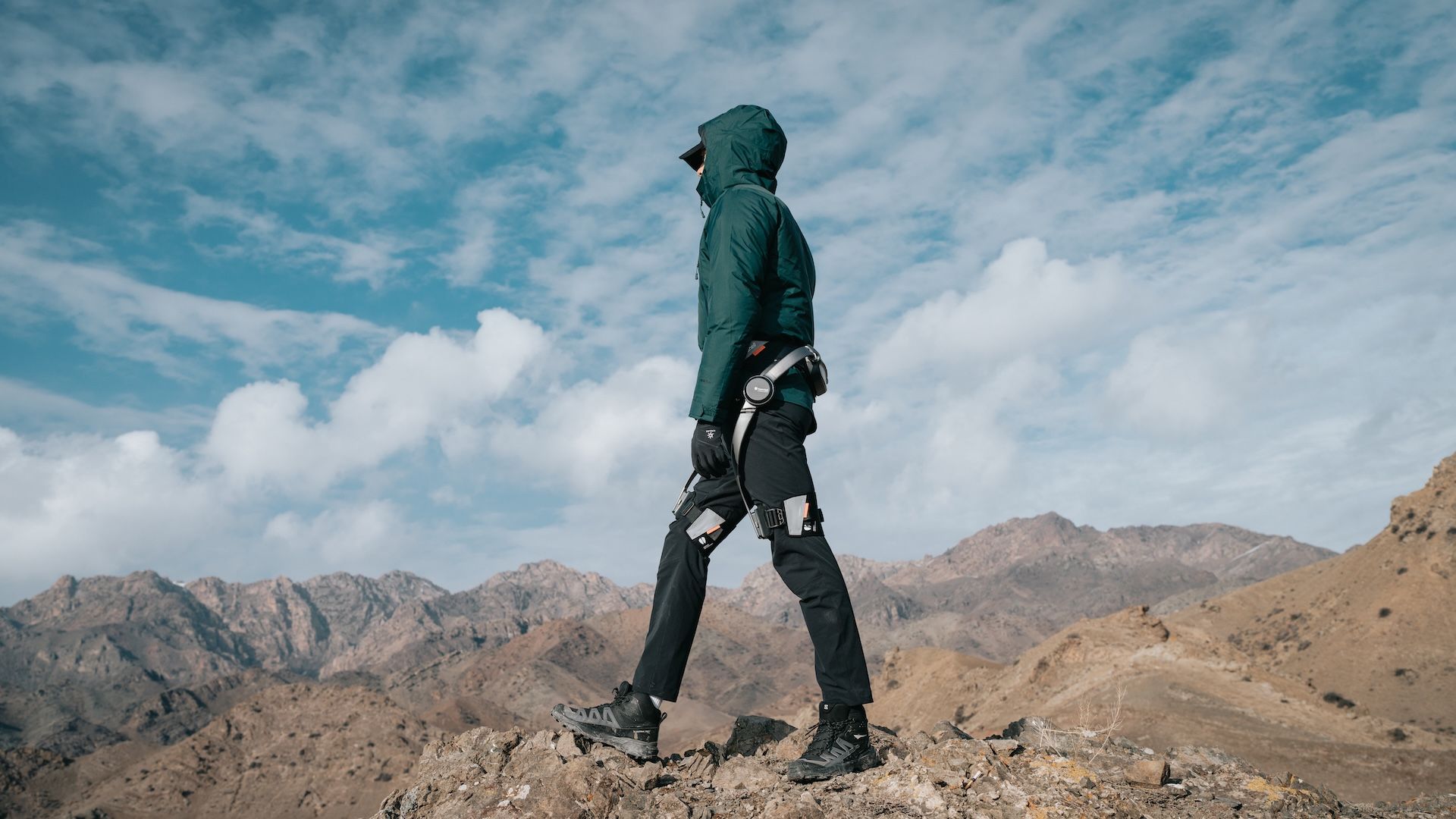 یک کاربر Hypershell X در حال پیاده روی در زمین کوهستانی Rocky.