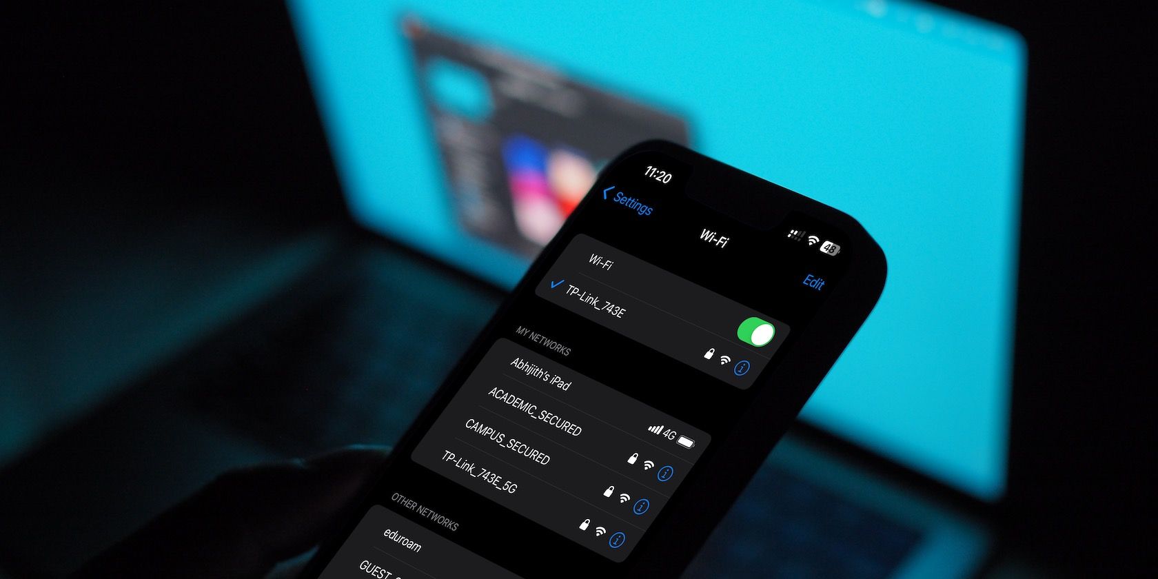 منوی WiFi آیفون با یک مک بوک در پس زمینه