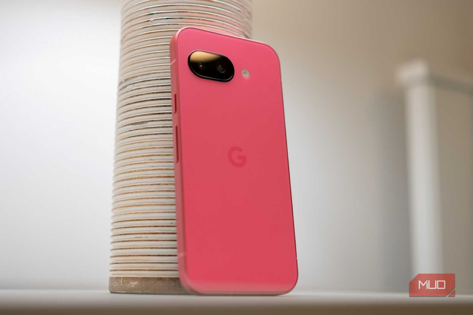 Google Pixel 9a روی یک میز نشسته است که پشت تلفن را نشان می دهد