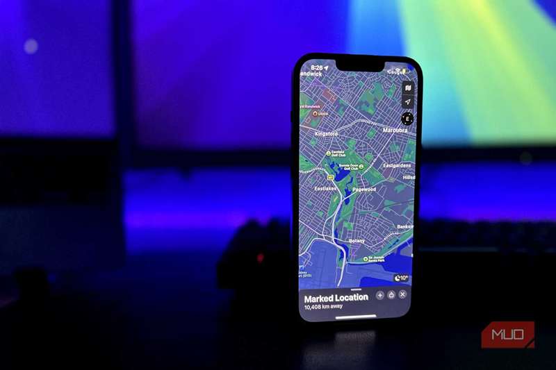 آیفون با برنامه Maps Open و MacBook و مانیتور در پس زمینه