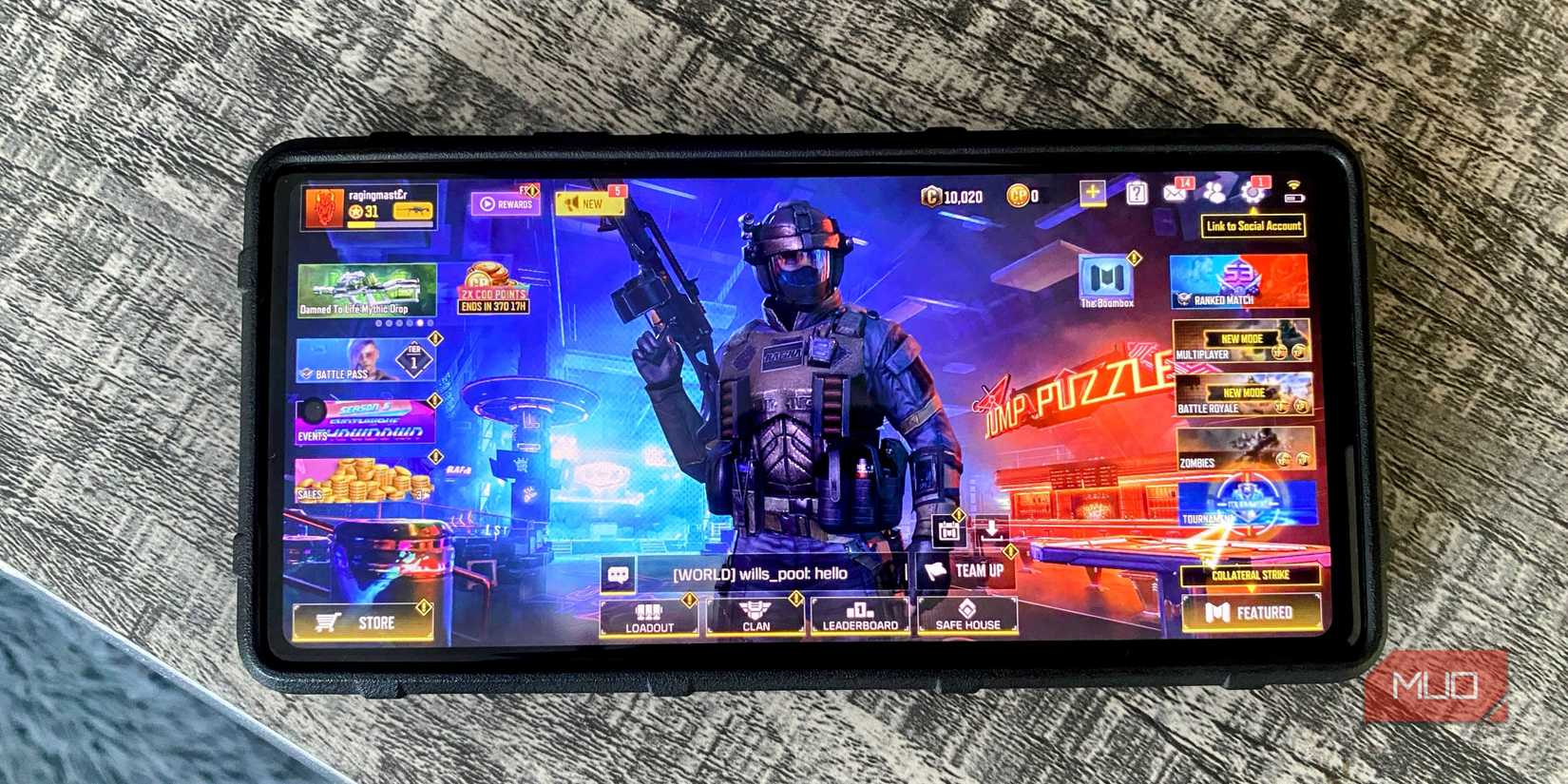 تلفن Android در بالای میز با صفحه اصلی بازی موبایل Call of Duty نمایش داده شده است