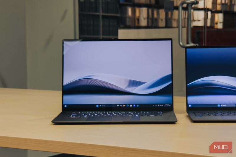 ASUS Zenbook S 16 روی میز چوبی با صفحه روشن