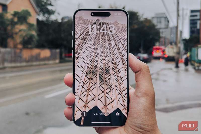 صفحهٔ iPhone 16 Plus در دست در مقابل پس‌زمینهٔ شهری