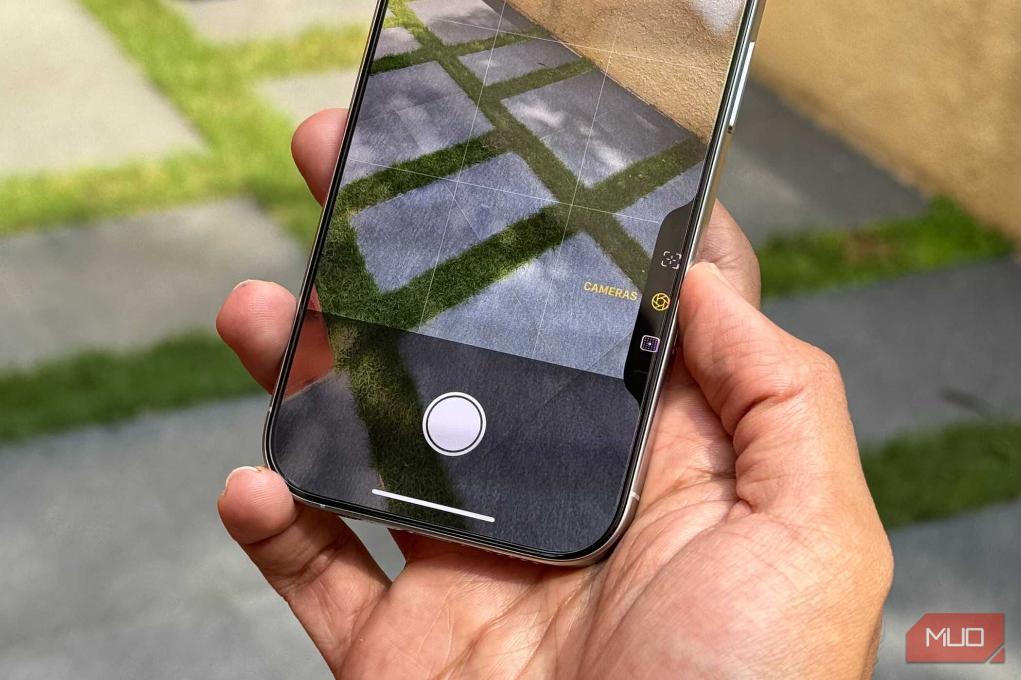 آیفون ۱۶ پرو در دست مرد نشاندندهٔ کنترل دوربین در برنامه دوربین