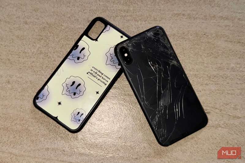 آیفون X با شیشهٔ پشت شکسته روی زمین با یک قاب