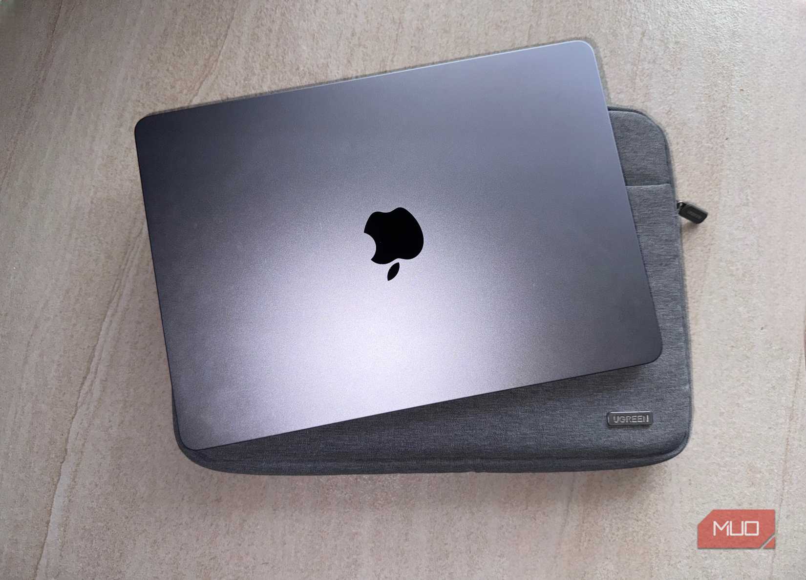 MacBook و یک آستین Ugreen روی یک سطح صاف.