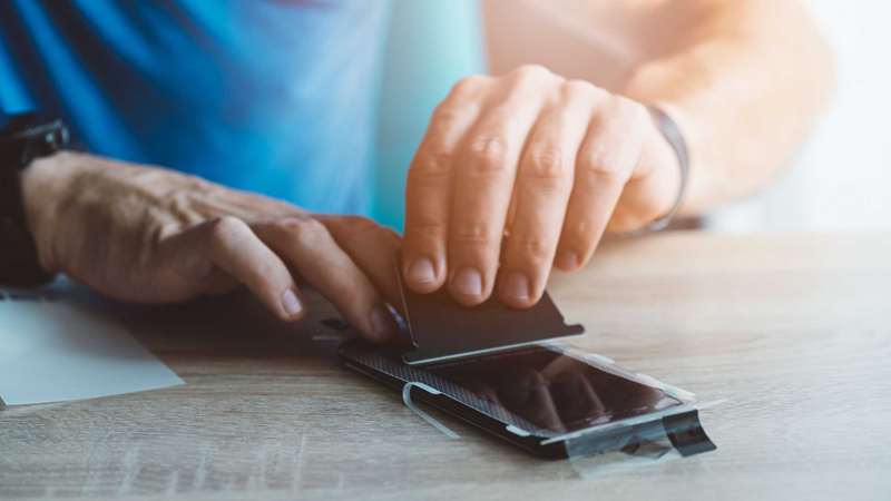 مرد در حال نصب محافظ صفحه‌نمایش بر روی گوشی