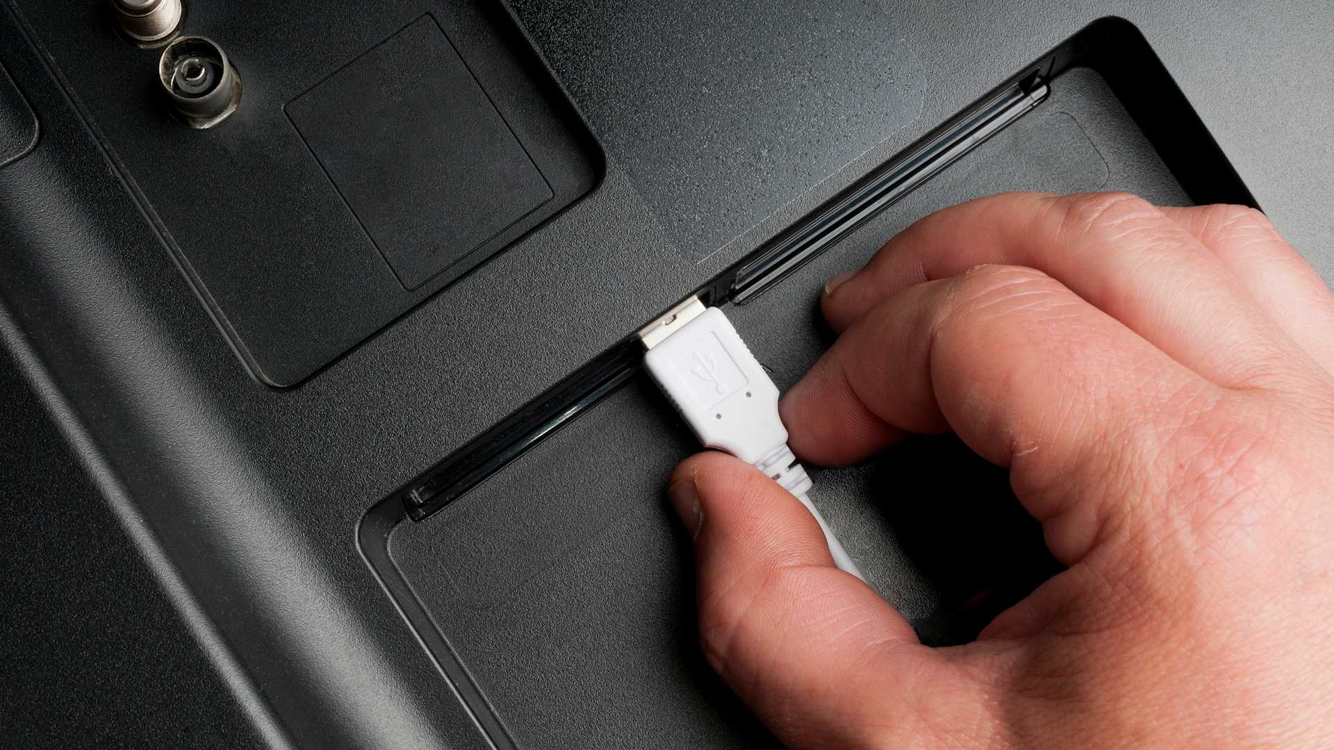 مردی که کابل USB نوع A را به پورت‌های پشتی تلویزیون وصل می‌کند
