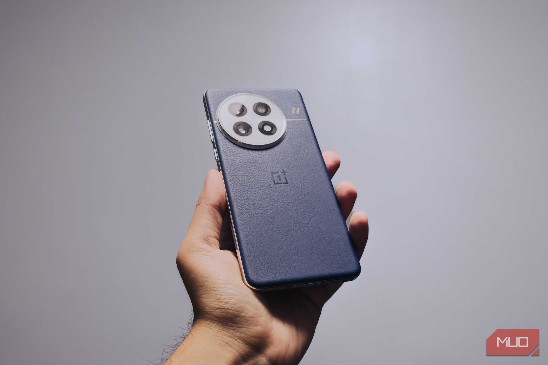 OnePlus 13 در دست به حالت زاویه‌دار در مقابل پس‌زمینه سفید