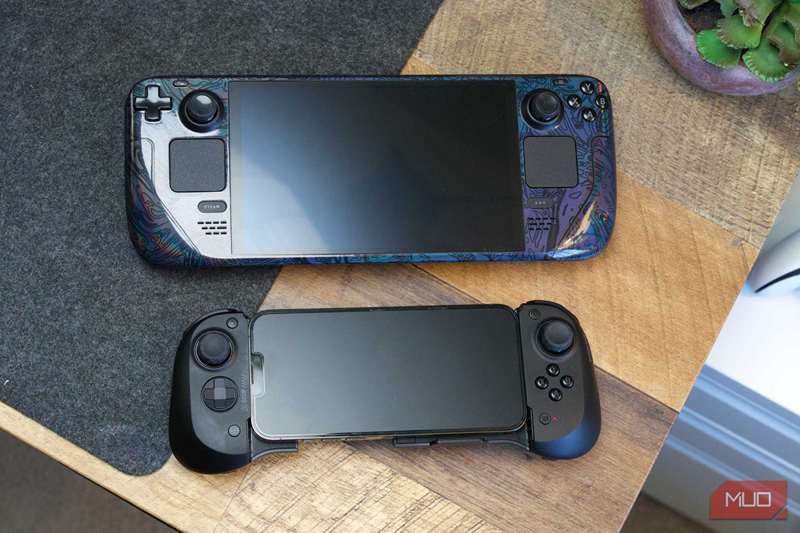 مقایسه Scuf Nomad با Steam Deck، هر دو روی گوشه‌ای از میز با پد نمدی خاکستری