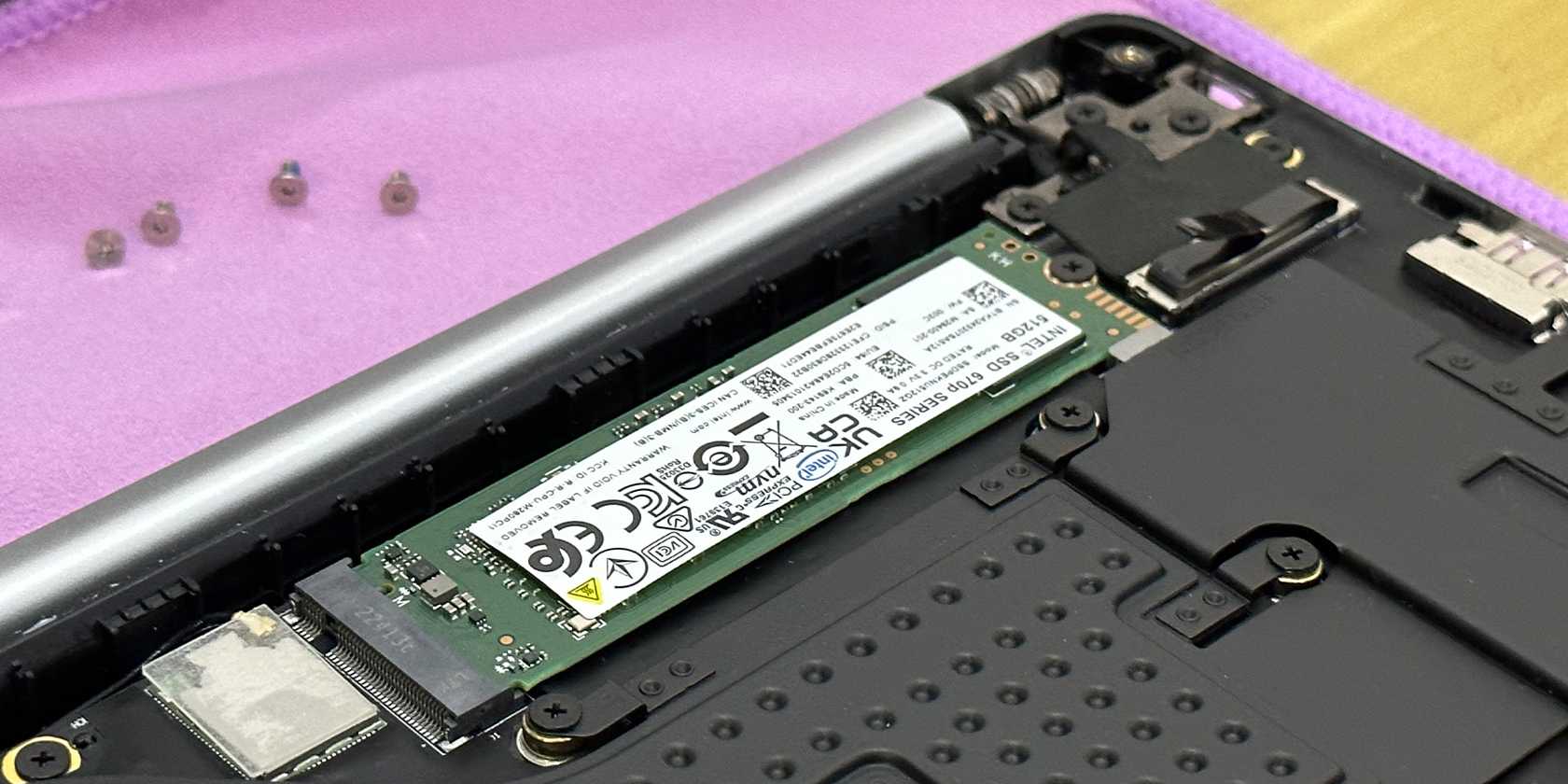 اسلات SSD Tecno Megabook T1 با پیچ‌های تورکس در پس‌زمینه