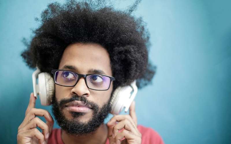 مرد با عینک فریم‌دار و هدفون