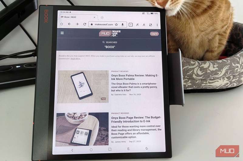 صفحه Boox Note Air 3 C نمایش وب‌سایت MUO و گربه‌ای که در گوشه مالیده می‌شود