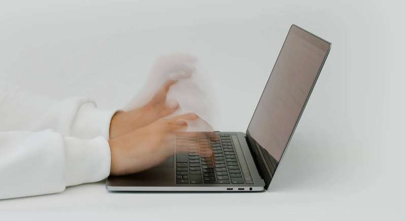 دست‌ها که به‌سرعت بر روی لپ‌تاپ تایپ می‌کنند