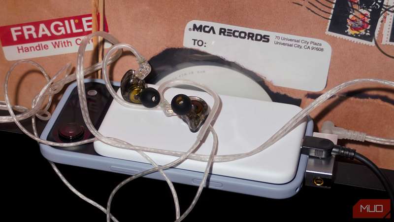 یک بسته باتری MagSafe، DAC، شارژر و هدفون‌ها که همه به یک گوشی متصل هستند