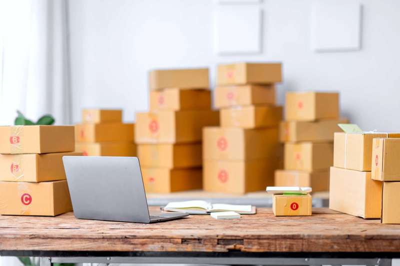 بسته‌ها در یک اتاق با لپ‌تاپ روی میز