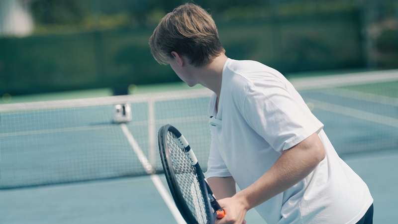 پونگ‌بات پِیس اس پرو در دوردست با یک بازیکن تنیس آماده به سوئیینگ