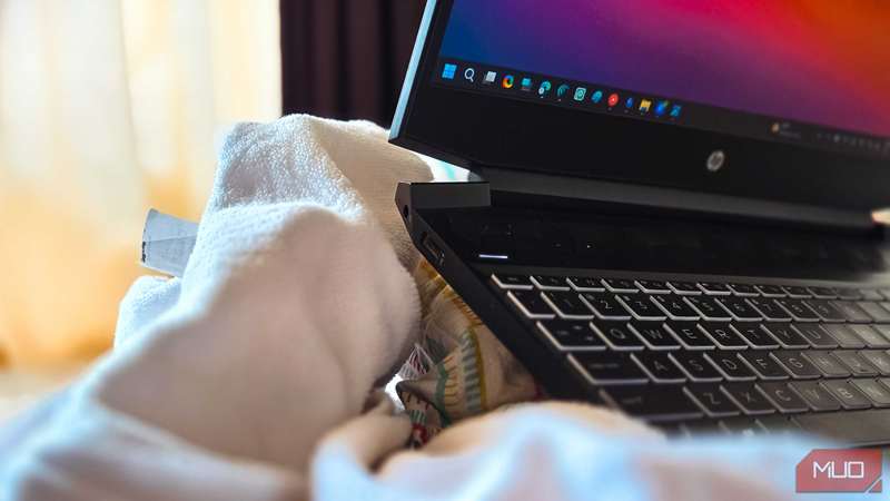 لپ‌تاپ HP Pavilion روی یک بالشت و یک ملحفه تخت که ورودی‌ها را مسدود کرده است