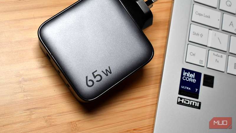 نمای بالا به پایین شارژر 65w ugreen کنار لپ‌تاپ.