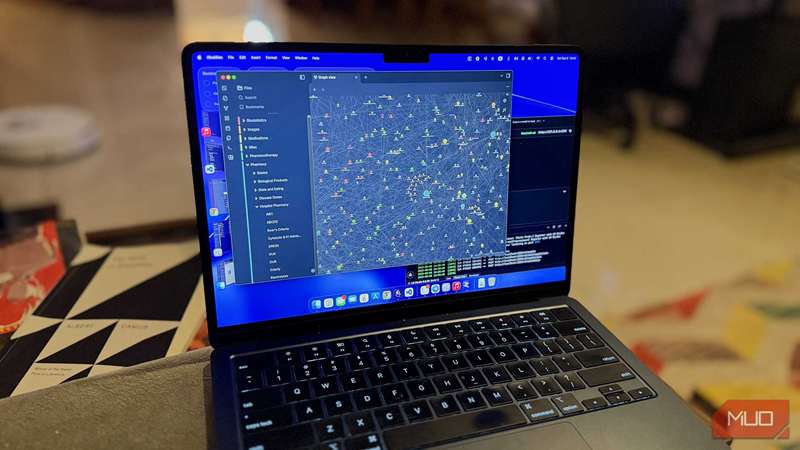 یک مک‌بوک روی یک sofa که نمای باز نمودار Obsidian را در کنار یک LLM محلی نشان می‌دهد