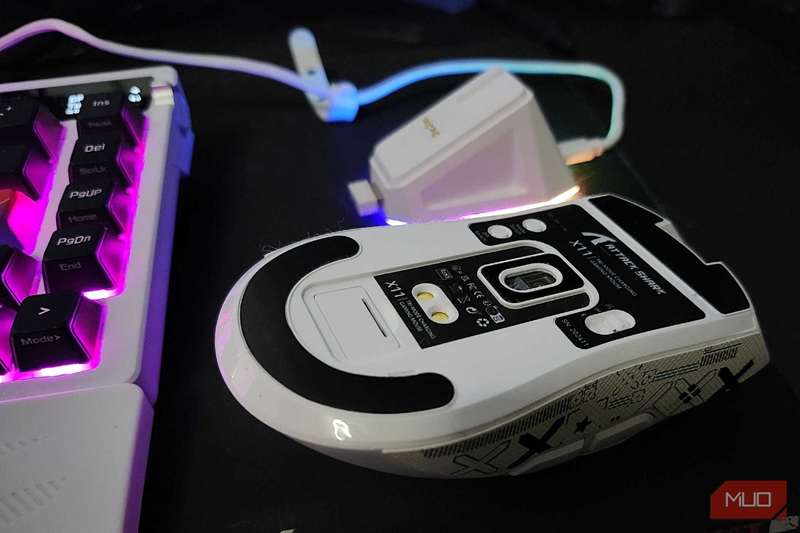 قسمت زیرین موش Attack Shark X11 با پایه شارژ در پس‌زمینه