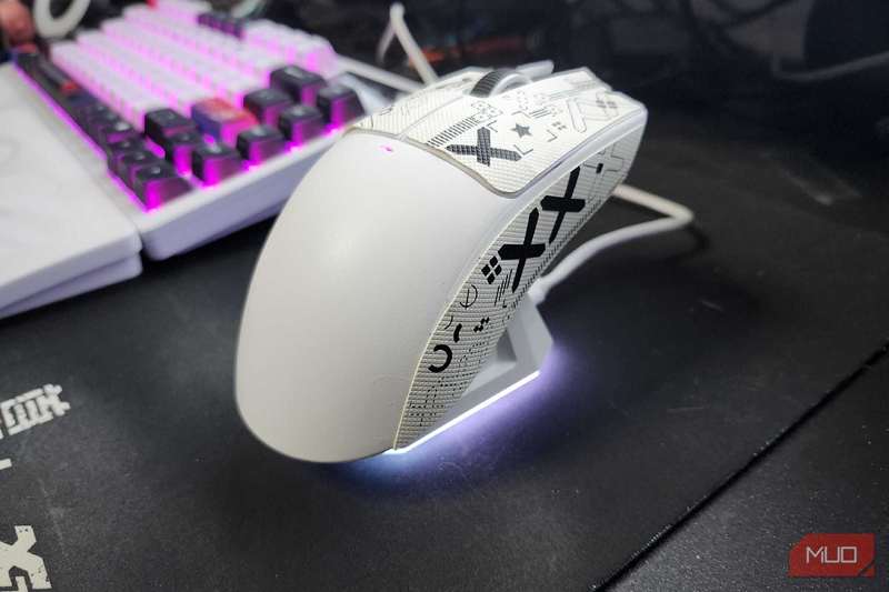 موش Attack Shark X11 روی پایه شارژ استراحت می‌کند، با نور LED که انتهای پایه را روشن می‌کند