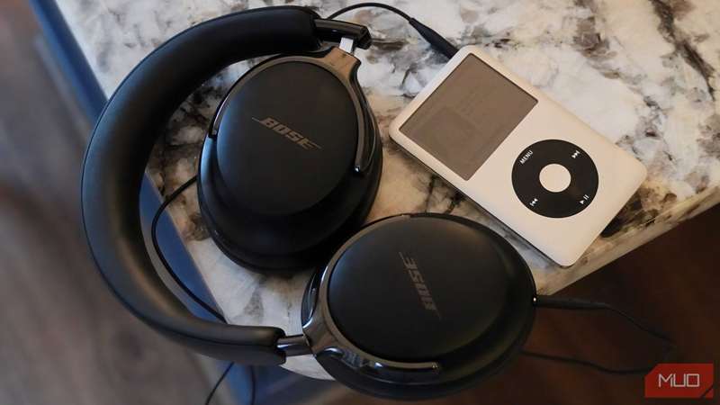 هدفون‌های Bose QuietComfort Ultra Gen 2 تا شده و به یک iPod وصل شده‌اند.
