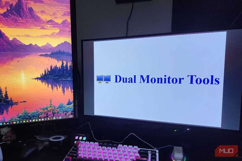 دو مانیتور روی میز کامپیوتر، با لوگوی Dual Monitor Tools روی مانیتور سمت راست