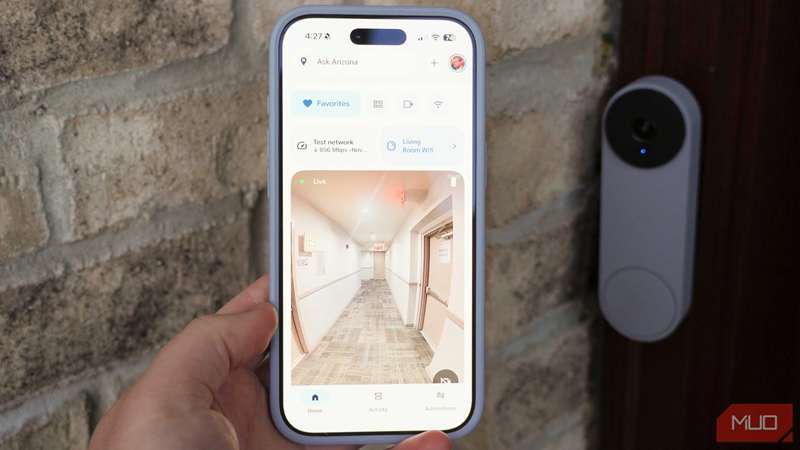 برنامه Google Home روی آیفون با یک زنگ در Google Nest در پس‌زمینه.