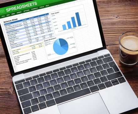 لپتاپ با جدول نمونه و نمودارها روی صفحه